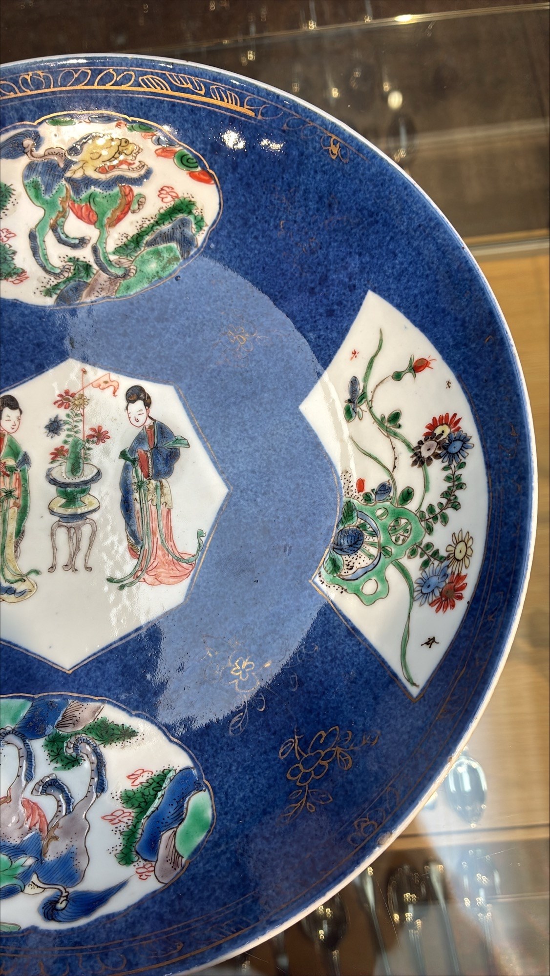 Chinese powder blue ground famille verte charger, possibly Kangxi, decorated with a central cartouche enclosing two female figures, with smaller shaped panels enclosing lions and foliage, square seal mark in blue to base, D28cm