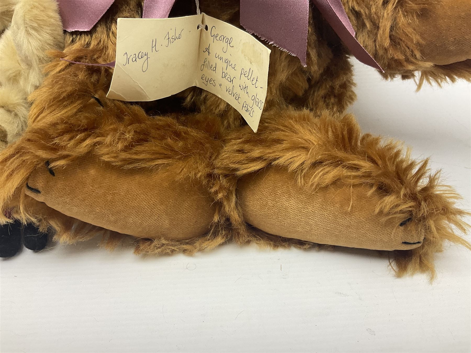 Group of five teddy bears comprising ‘George’ a unique pellet filled bear with glass eyes and velvet paws H38cm, and ‘Abbey’ a luxury German plush with wobble head and glass eyes no.5/10 H24cm, both with Teddies from Bearyland labels; along with two light blonde mohair H. M. Bears and Boyds Bears ‘T. F. Wuzzies’ no. 595140 (5)
