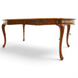 Dutch design figured walnut extending dining table, the shaped circular extending top with book-matched veneer and moulded edge, shaped banded frieze over scroll-moulded lower rail, raised on C-scroll carved cabriole supports with pad feet, with additional leaf