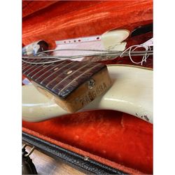 1963 Fender Jazz three-knob bass guitar; impressed with date code 7AUG63A on end of neck and serial no.L08587 on back plate; all original but re-finished in white in the 1970s; sold with photographs of the instrument in the 1960s with original finish and in the 1970s re-finished; L117.5cm; in original hard carrying case; Provenance: the professional guitar of Howard Livett from new to his death in 2005. Howard played in The Humperdincks, the backing group for Englebert Humperdinck, also played in the backing group for Max Bygraves and in the band Hedgehoppers Anonymous. The guitar is also sold with a manuscript letter of provenance from Howard's wife.