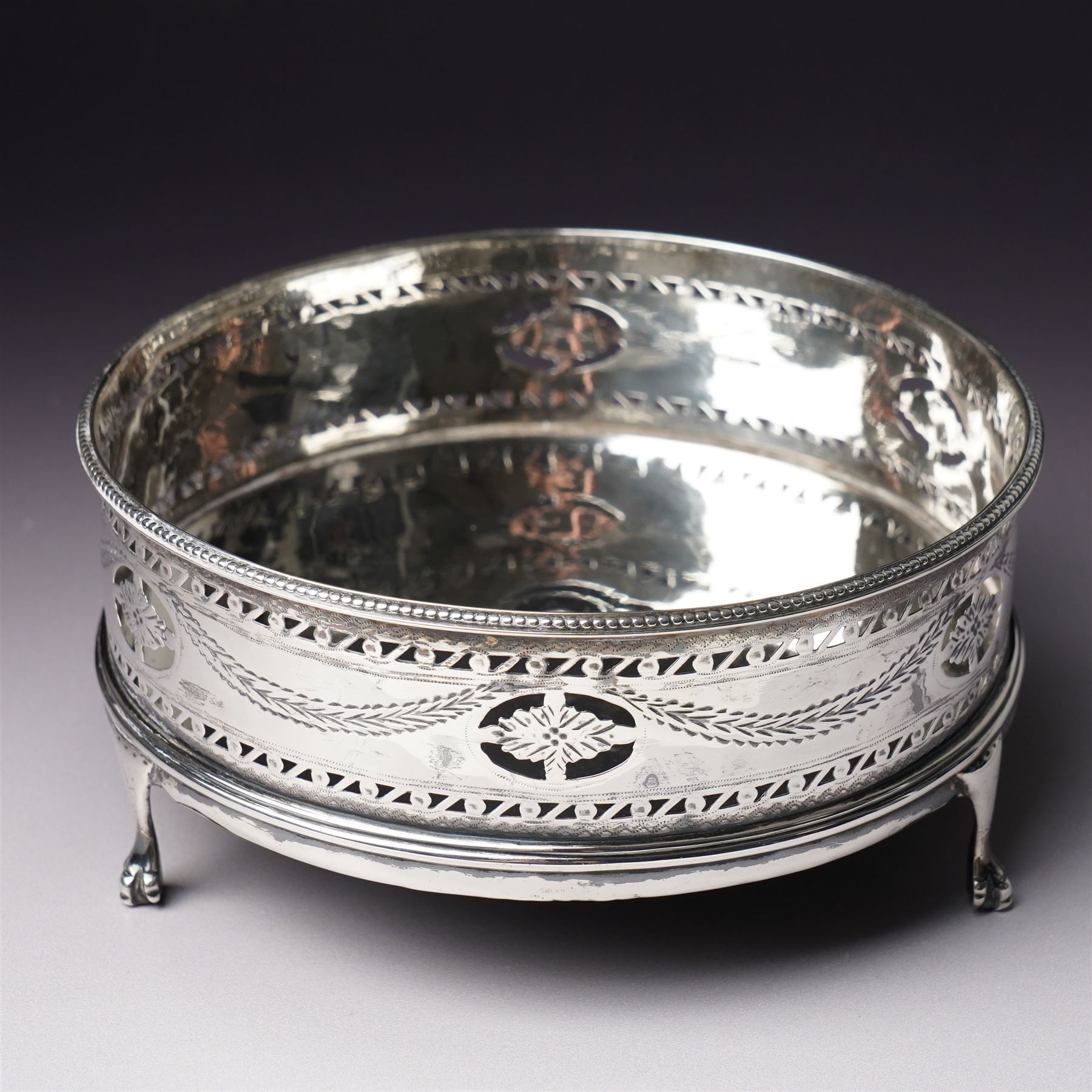 George III silver circular stand, originally a cruet stand, with pieced rim decorated with garlands and swags with turned wood base on claw and ball feet D14cm