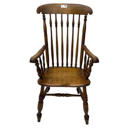 Early 19th century elm farmhouse armchair, the shaped eared cresting rail over tall spindle back, dished seat on turned supports united by H stretchers