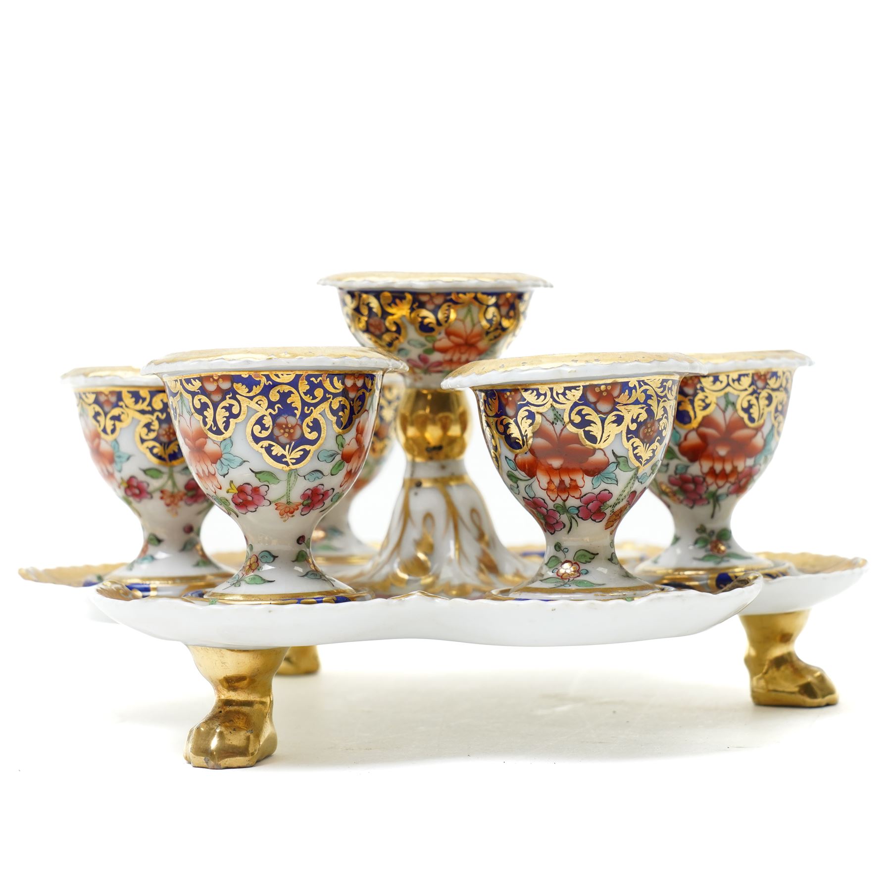 Early 19th century Chamberlain's Worcester egg stand of serpentine circular form fitted with five egg cups and decorated with flowers on a blue and gilt ground with gilt border and on paw feet D20cm. Printed mark used on the Regent body circa 1811-1820 
Provenance: property of a Nobleman