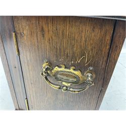 Early 20th century oak smokers cabinet, with twin twin drop handles to sides, hinged lift up top and twin doors to front carved with foliate panels, opening to reveal a compartmented interior, H27.5cm W38cm D21.5cm