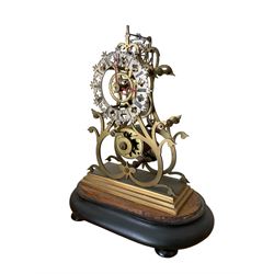 English-Late 19th century 8-day Skeleton clock on an oval ebonised base c1880, with pierced brass plates and silvered chapter ring, Roman numerals and gothic trefoil hands, chain driven five-pillar fusee movement and pierced mainspring barrel cap, timepiece movement with key and pendulum. 