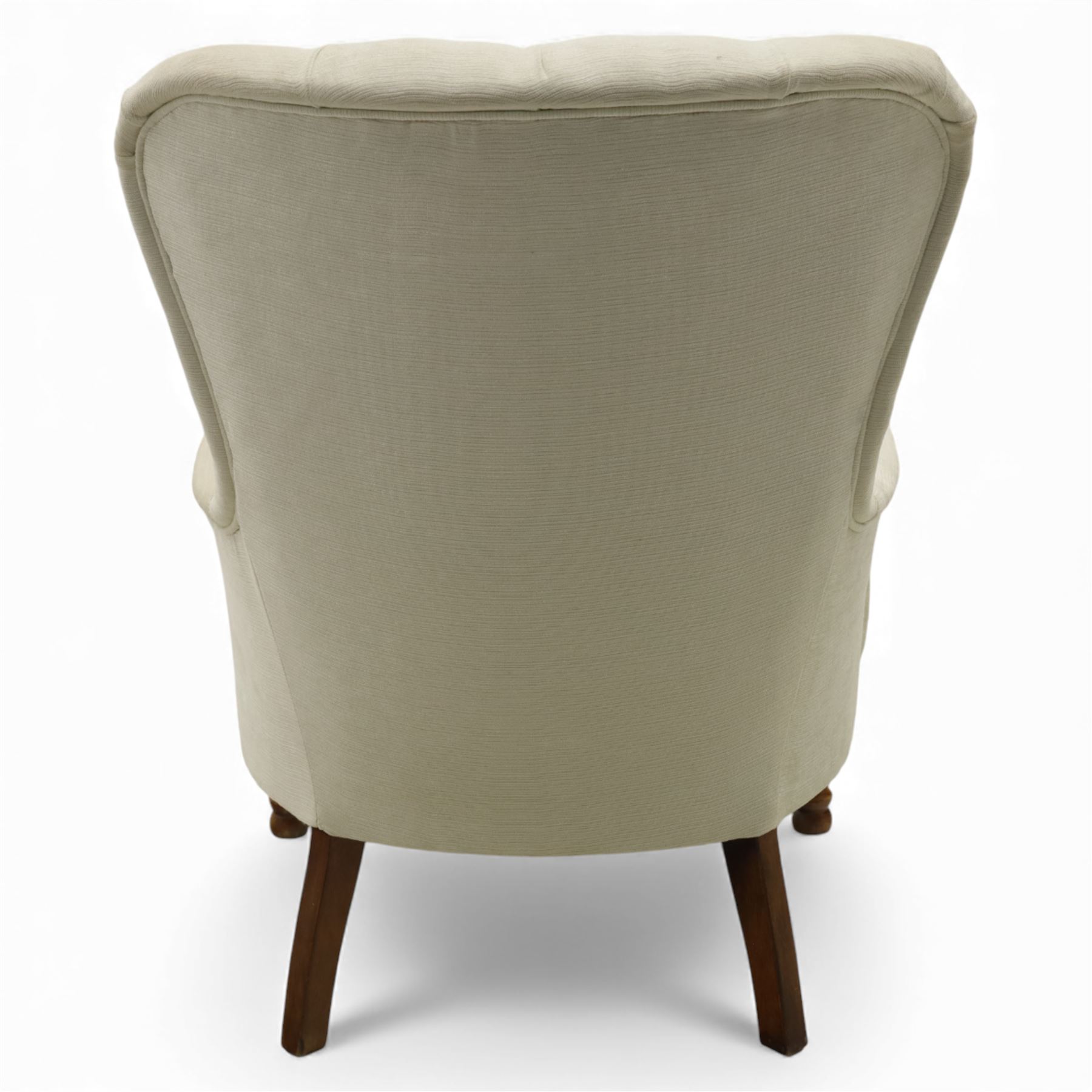 Late 20th century cream upholstered nursing chair, high button-tufted back with shaped wings, scroll arms, loose seat cushion, raised on turned front supports