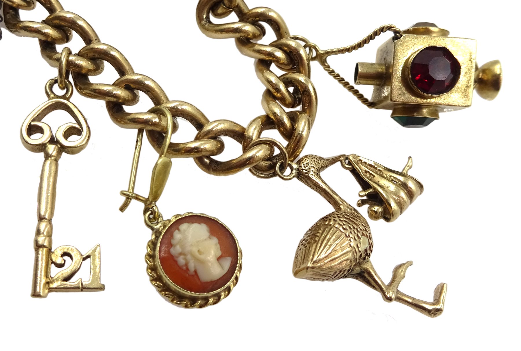 9ct gold curb bracelet with heart locket hallmarked,  with ten 9ct gold charms including stork carrying a baby, house, first aid box and an 18ct gold cross charm, all tested, hallmarked or stamped