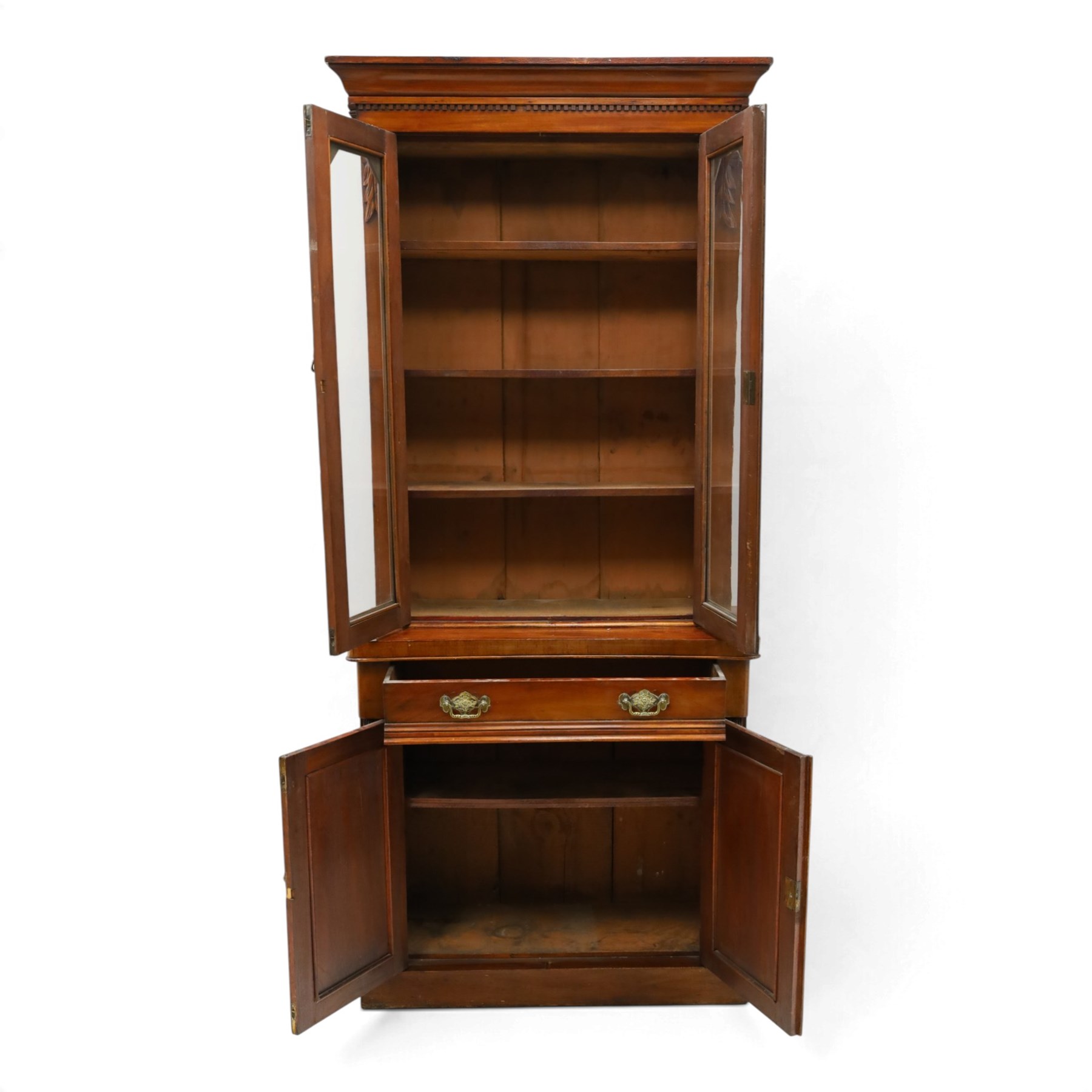 Victorian mahogany bookcase on cupboard of slender proportions, projecting cornice over dentil-frieze, fitted with twin-glazed doors enclosing three shelves, flanked by acanthus corbels, the base fitted with single frieze drawer over panelled cupboard, on skirted base