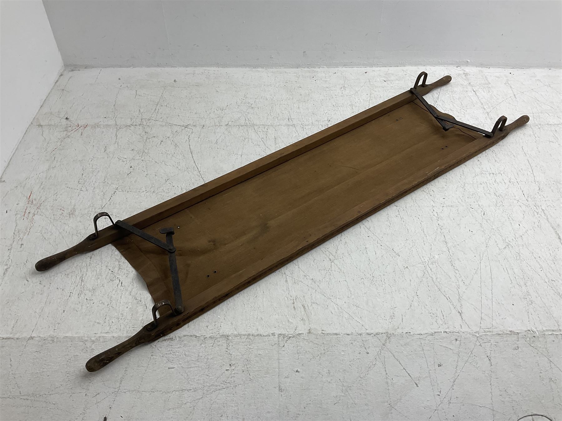 WW1 British casualty stretcher with iron mounted pitch pine sides and canvas base; stamped 'HL1917' and L7 with broad arrow in a triangle L236cm ( reputedly recovered from a barn at Bapaume on The Somme)