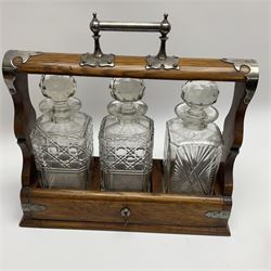 A Mappin & Webb silver plate mounted oak tantalus, containing three square sided cut glass decanters, complete with key, H35cm, together with a further square sided decanter. 