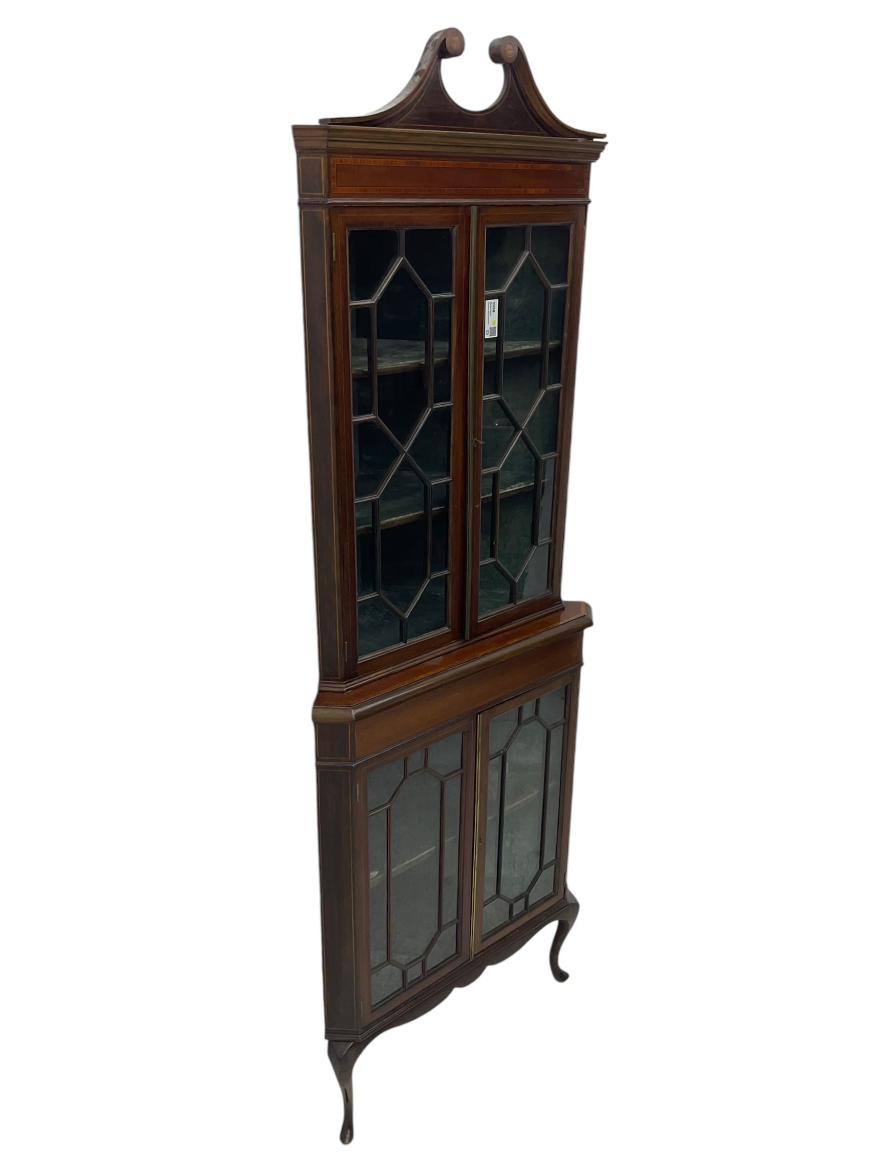 Edwardian mahogany corner display cabinet, scrolled swan neck pediment over astragal glazed doors, fabric lined interior, on cabriole feet 