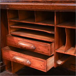 Early 20th century oak twin pedestal roll top desk, tambour roll enclosing small drawers and pigeon holes, fitted with seven drawers, on plinth base 