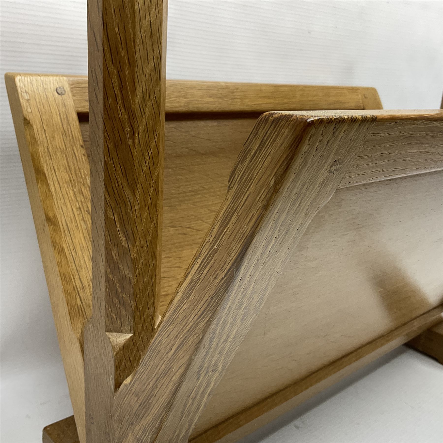 Mouseman - oak magazine rack, the top rail pierced with handle and carved with mouse signature, octagonal supports with two panelled and splayed sides, on sledge feet, by the workshop of Robert Thompson, Kilburn 