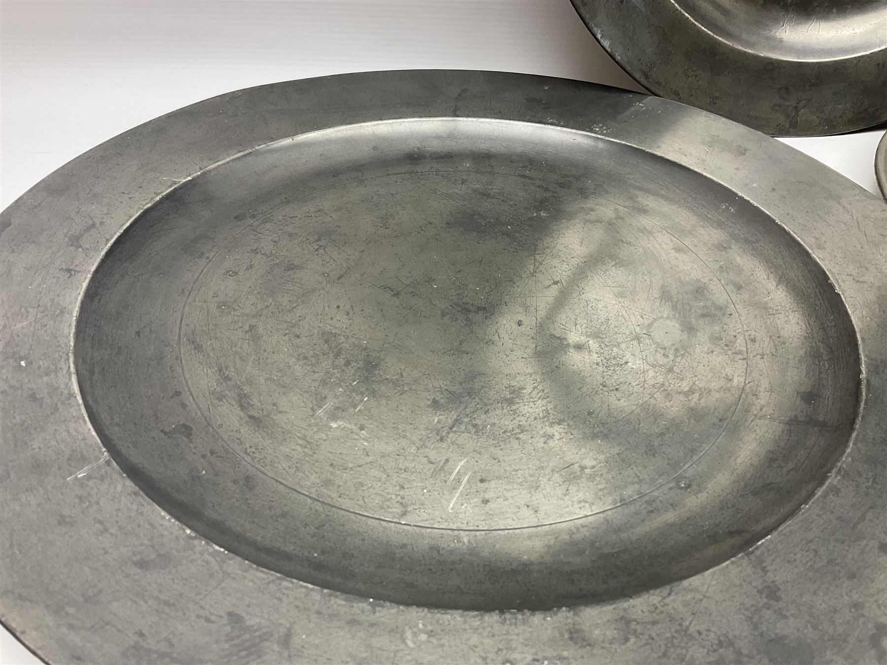 Group of seven 19th century pewter chargers, each of circular form with dished centre, two examples with touch marks verso, each approximately D39cm