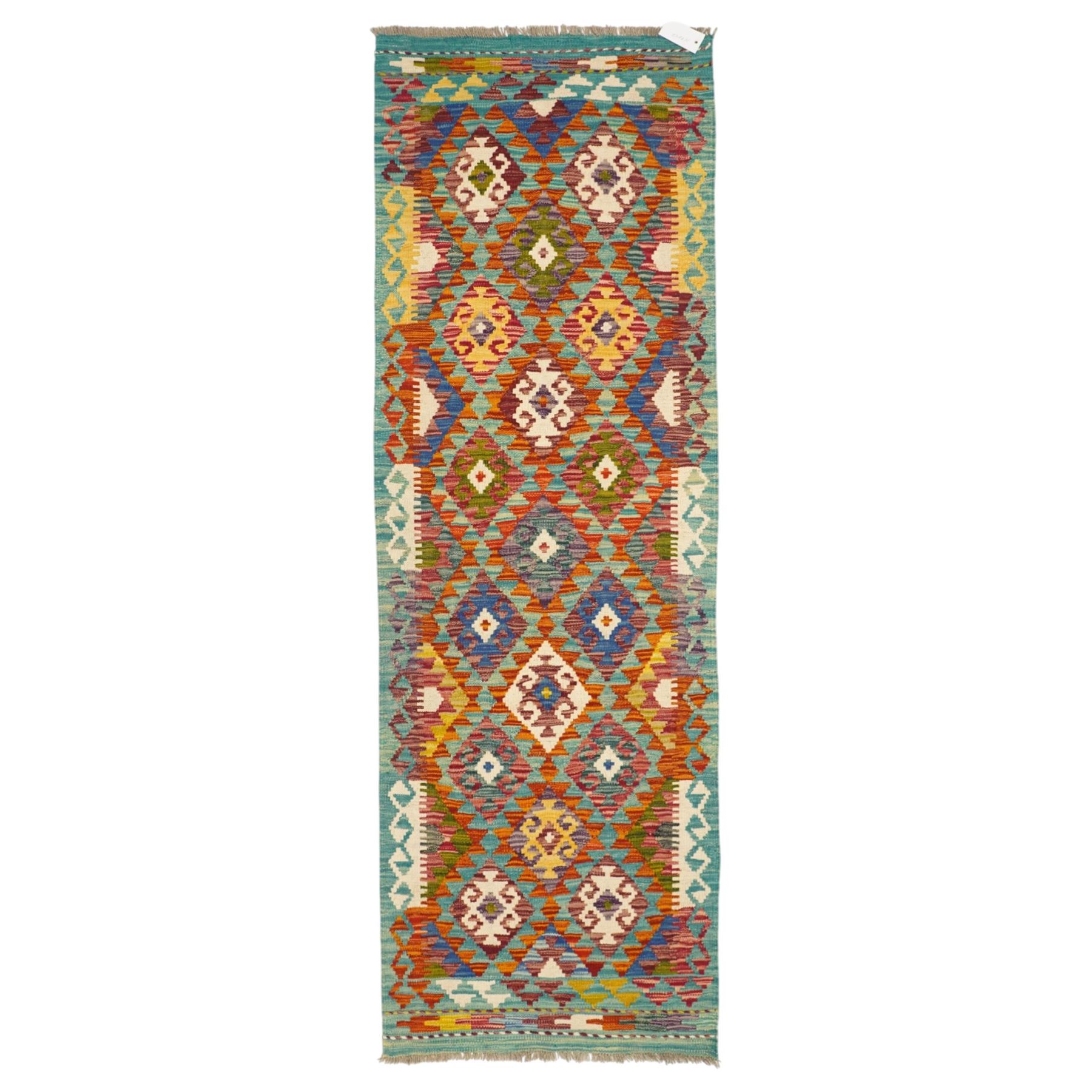 Afghan Maimana flatweave kilim runner, central field features large bold nested diamond motifs and stylized geometric lozenge patterns on olive purple, blue, and green tone ground, border stripe in mustard ground, and fringe