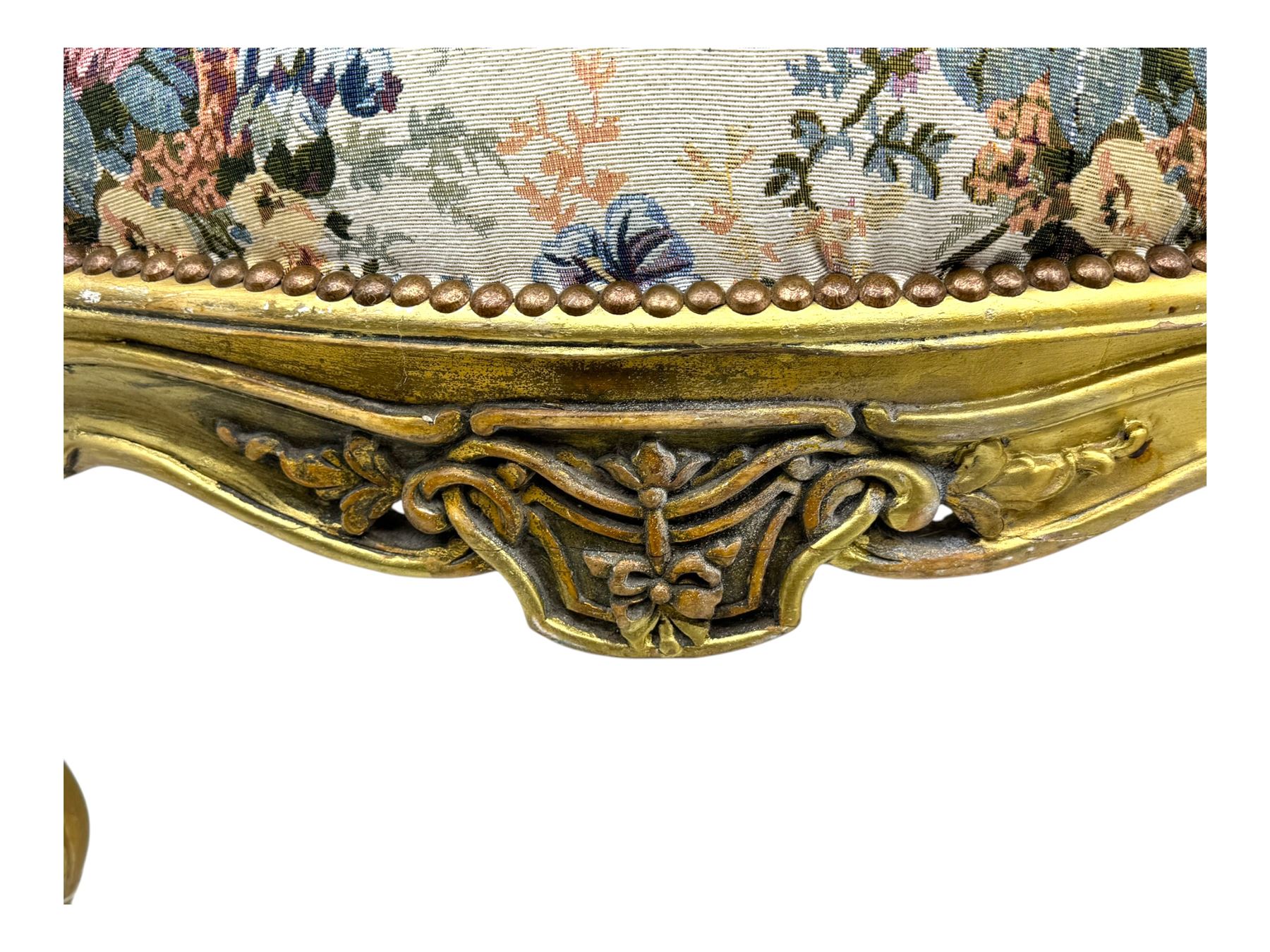 Pair of Louis XV-design giltwood stools, each upholstered in floral tapestry fabric, the carved frame adorned with scrolling foliage and shell motifs, raised on cabriole supports