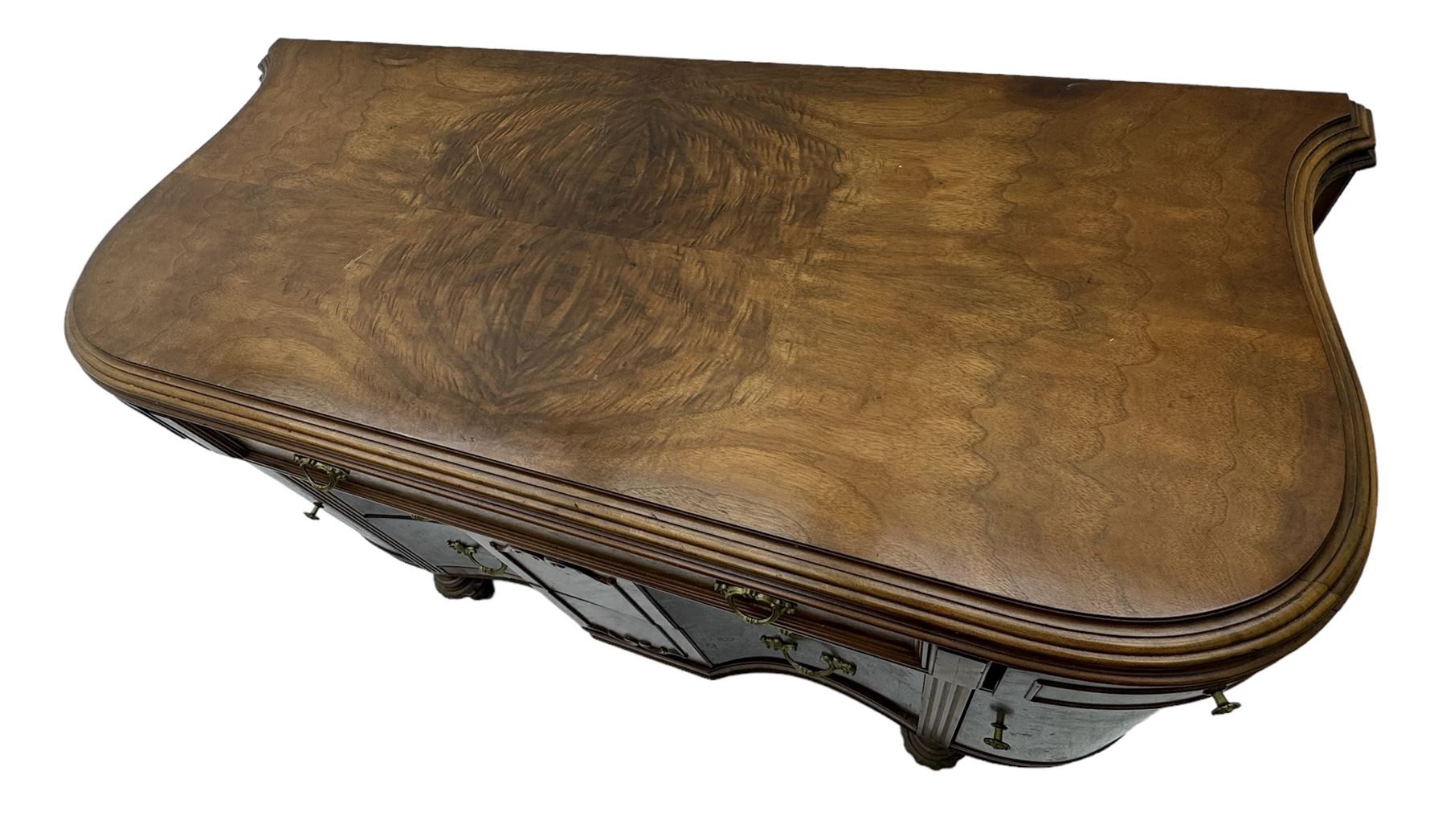 Late 20th century Italian walnut sideboard, serpentine front and bow-shaped top with highly figured veneer, single checkered-pattern frieze drawer over two drawers with central foliage cartouche, flanked by hinged frieze drawers over cupboards, on turned and carved supports
