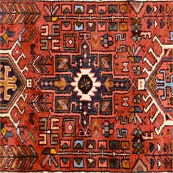 North West Persian Heriz hand-knotted runner, terracotta field decorated with a series of large angular medallions with stylized geometric motifs, surrounded stepped devices, and stylized trees within narrow geometric border, and polychromed edge, cotton fringe ends 