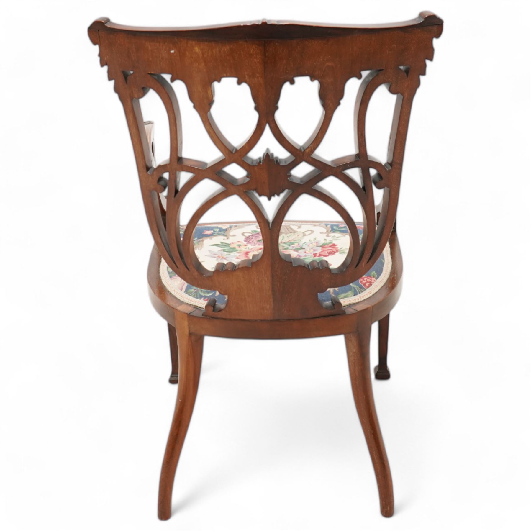Edwardian inlaid mahogany elbow chair, satinwood banded cresting rail decorated with acanthus leaf carving, open pierced and interlaced back inlaid with curled foliage, floral pattern fabric upholstered seat, on square tapering supports with compressed spade feet
