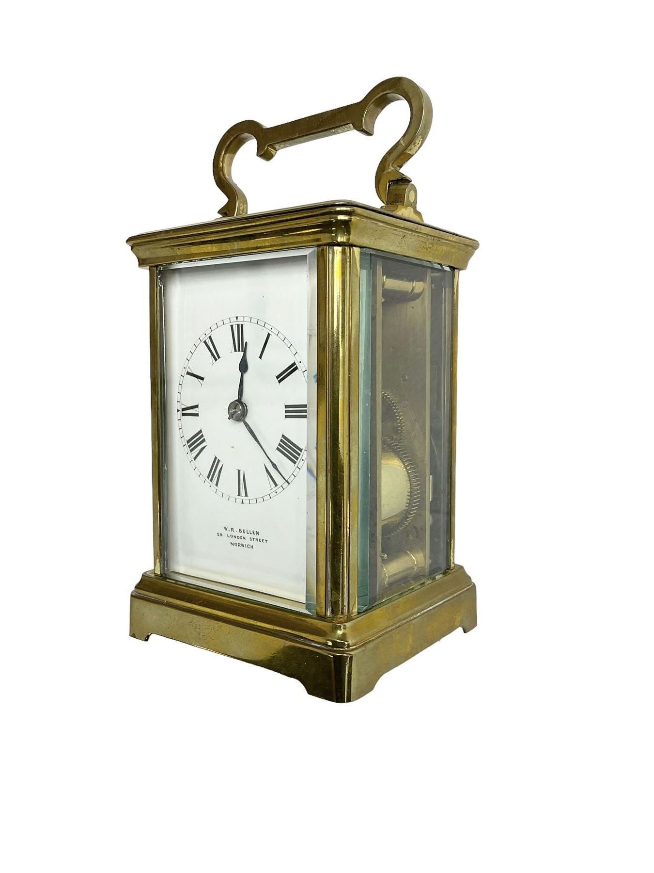 W.R. Cullen, London Street. Norwich. - 8-day French carriage clock c1900, in a corniche case with carrying handle and four bevelled glass panels, white enamel dial with Roman numerals, minute markers and spade hands, with a lever platform escapement and rack striking movement striking the hours and half hours on a coiled gong. 