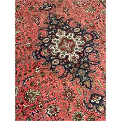 North West Persian pink ground Tabriz carpet, central indigo ground medallion surrounded by stylised plant motifs and trailing foliage, the main border with overall floral design within guard stripes 