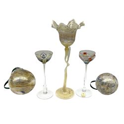 Two early 20th century Theresienthal enamelled liqueur glasses, the shallow coup bowls decorated with  colourful floral design and edged with gilt raised upon slim tapering stems with circular spreading foot, together with an art glass flower in the style of Karl Kopping with curving stem and leaf signed indistinctly Rachel (Kustall Franenam?) and two further art glass balls