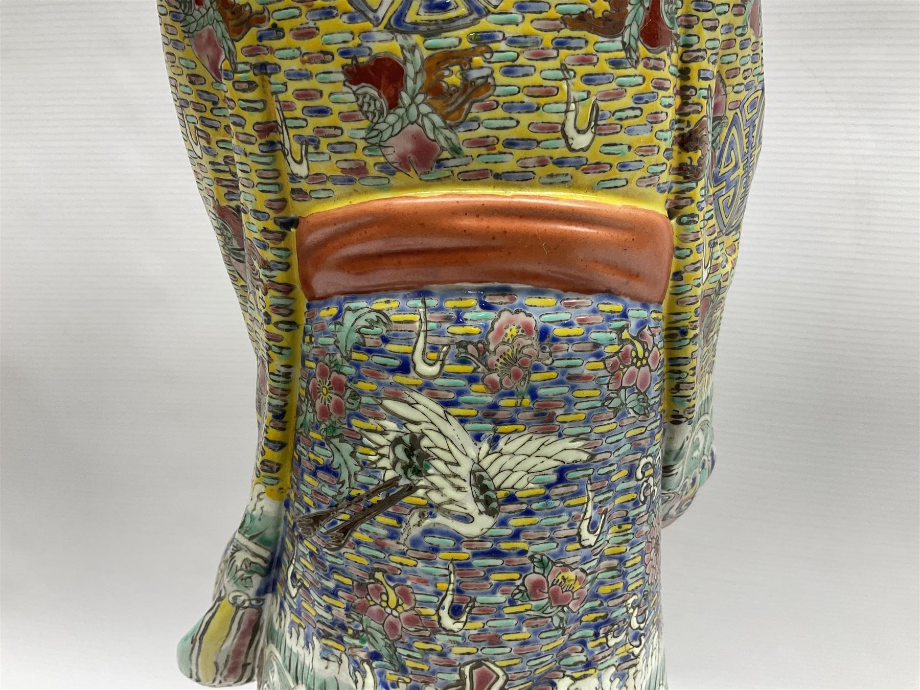 Chinese Republic Period porcelain figure, modelled as Shoulao, wearing elaborately enamelled robes decorated with peaches and flower heads, with impressed mark beneath, H55cm