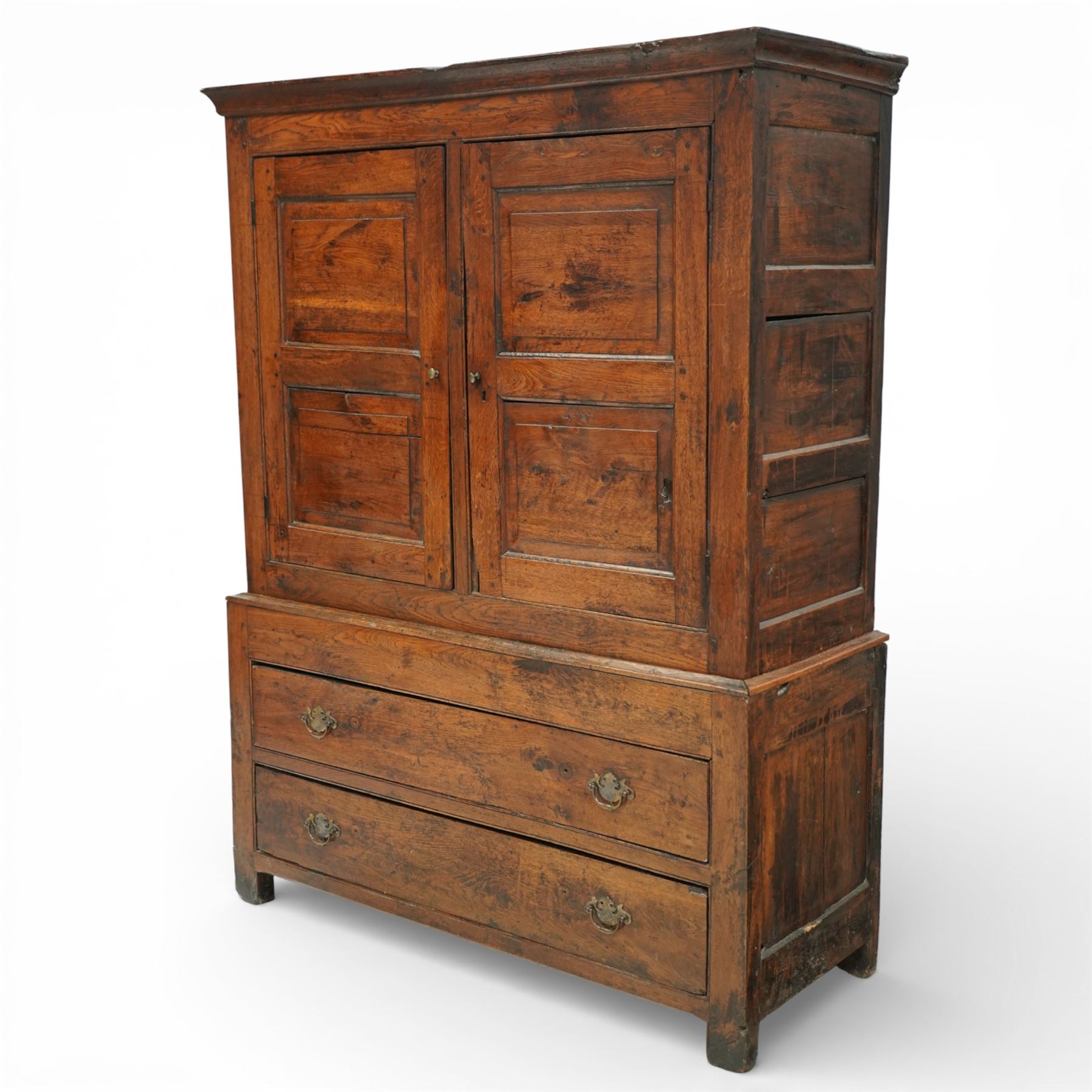 Georgian rustic oak housekeeper’s cupboard, moulded cornice above a pair of fielded panel cupboard doors enclosing a boarded interior with central divider and hanging hooks, the base fitted with two long drawers with brass swan neck handles, raised on stile supports
