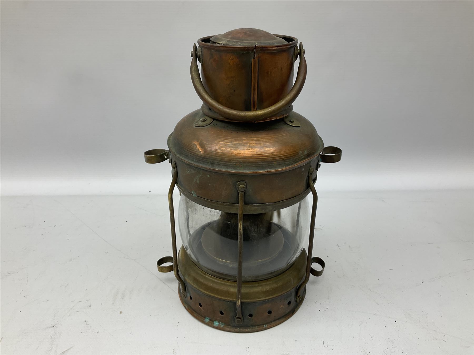Copper and brass ship’s lamp marked ‘Anchor’, H25cm, Feuer hand storm lantern, Bialaddin Model 315 paraffin lamp and an Anchor lamp (4)