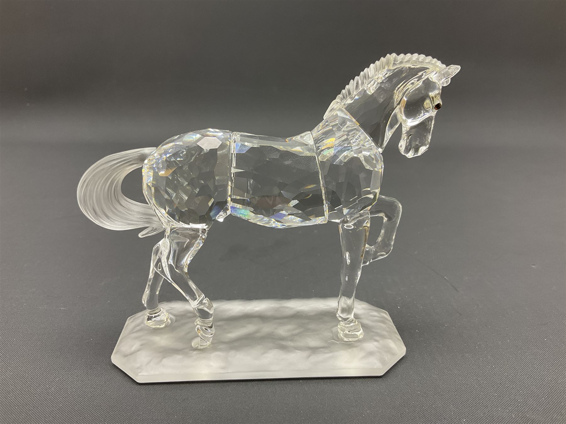 Five Swarovski Crystal horses, comprising stallion, rearing horse, pair of horses playing and Arabian stallion, each with frosted manes and tails, together with a small Swarovski Crystal galloping horse, the mane, tail and base with smoky tint