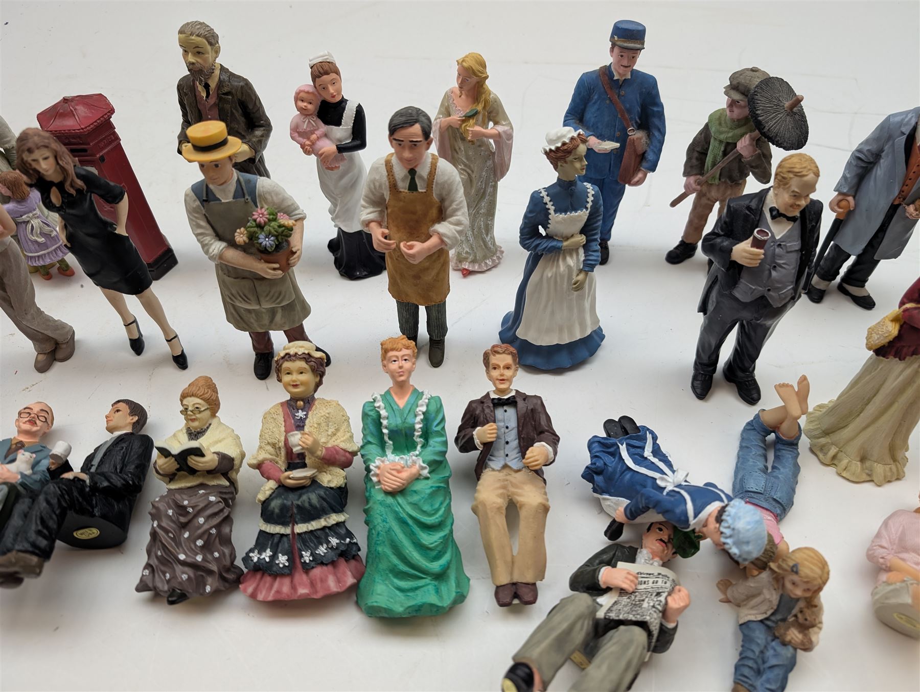 1:12 scale dolls house composite figures, including policeman, postman, maid, sitting and standing people in various styles of dress, etc
