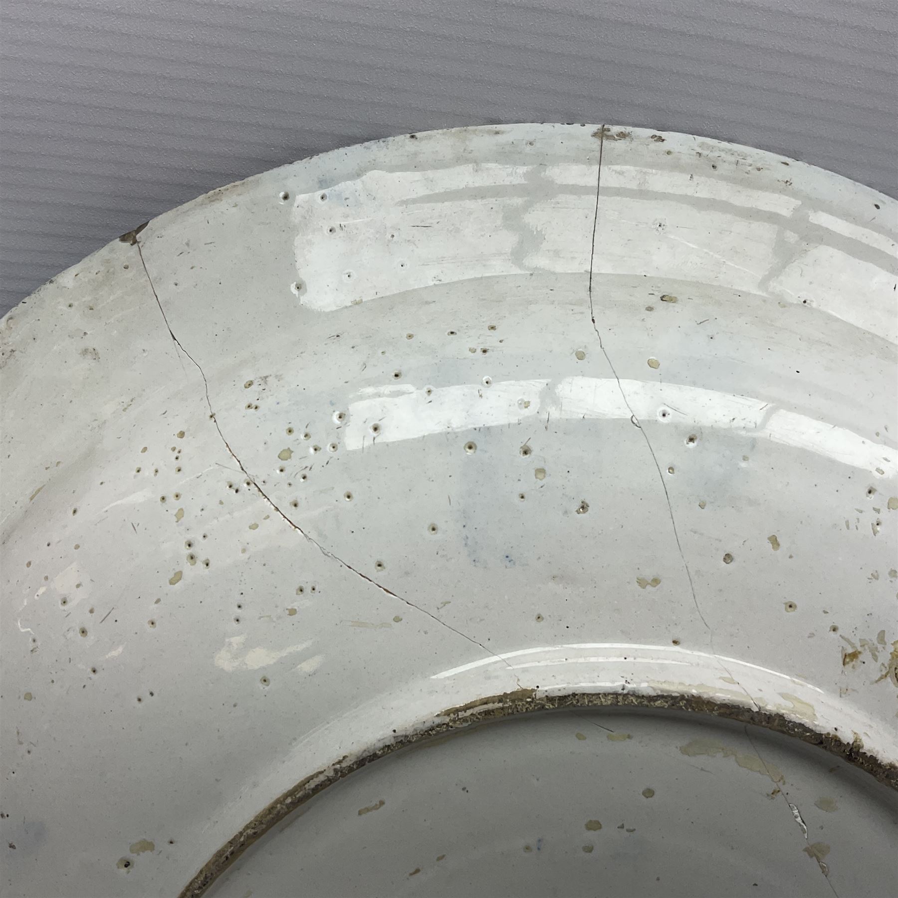 Early 18th century Delft marriage plate, of circular form with dished centre, the centre inscribed and dated 'Thomas and Elizabeth Kockerill Bridlington Key 1715' within a crowned C scroll cartouche, flanked by demi-griffins, above a putto head and tassels, within a wide foliate border, D34cm
