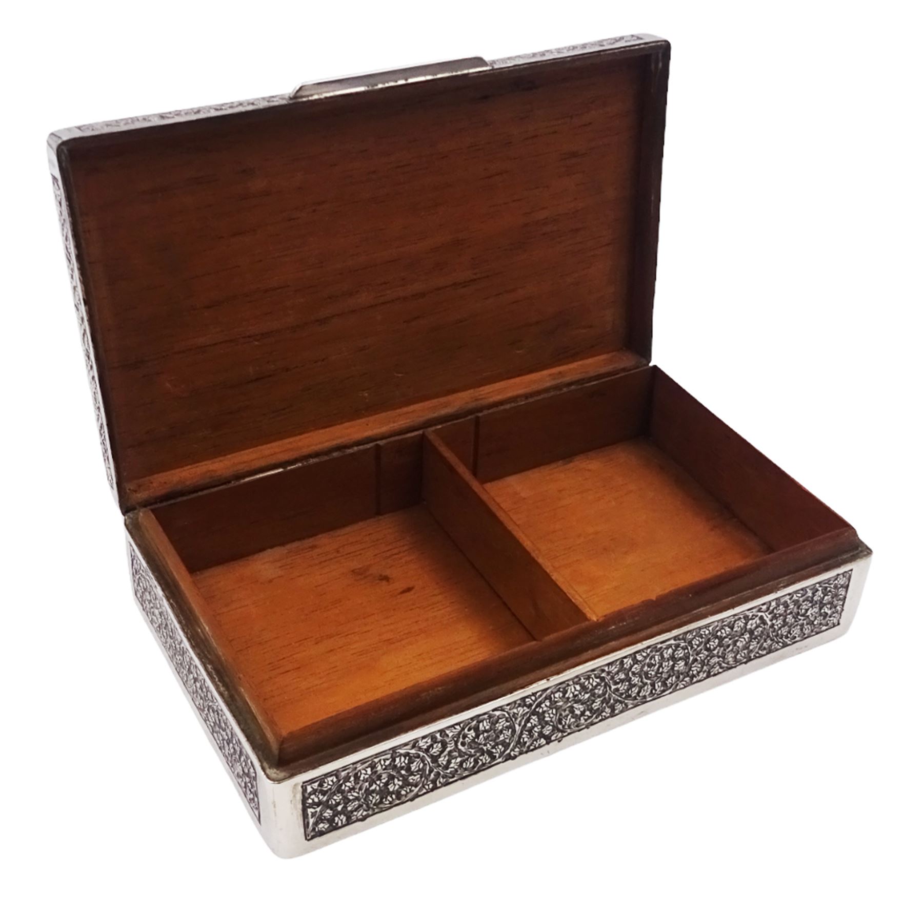 Indian silver cigarette box, of rectangular form with chassed and embossed foliate decoration and vacant rectangular panel to hinged cover, opening to reveal softwood lined interior with division, H3.3cm W14.3cm D8.5cm, stamped Silver VR Co with elephant mark
