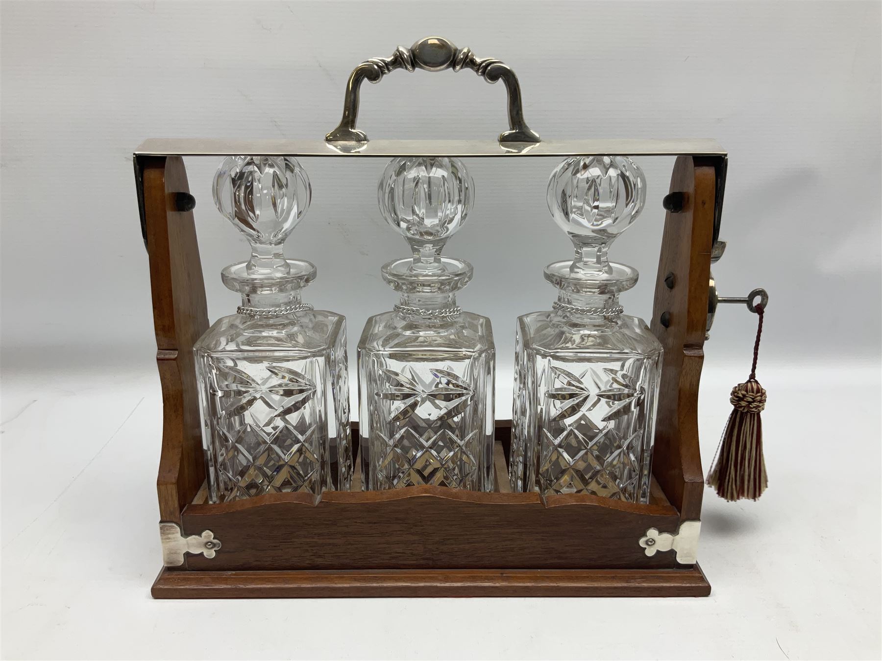 Edwardian silver plate mounted oak tantalus, containing three square sided cut glass decanters, complete with key, H33cm