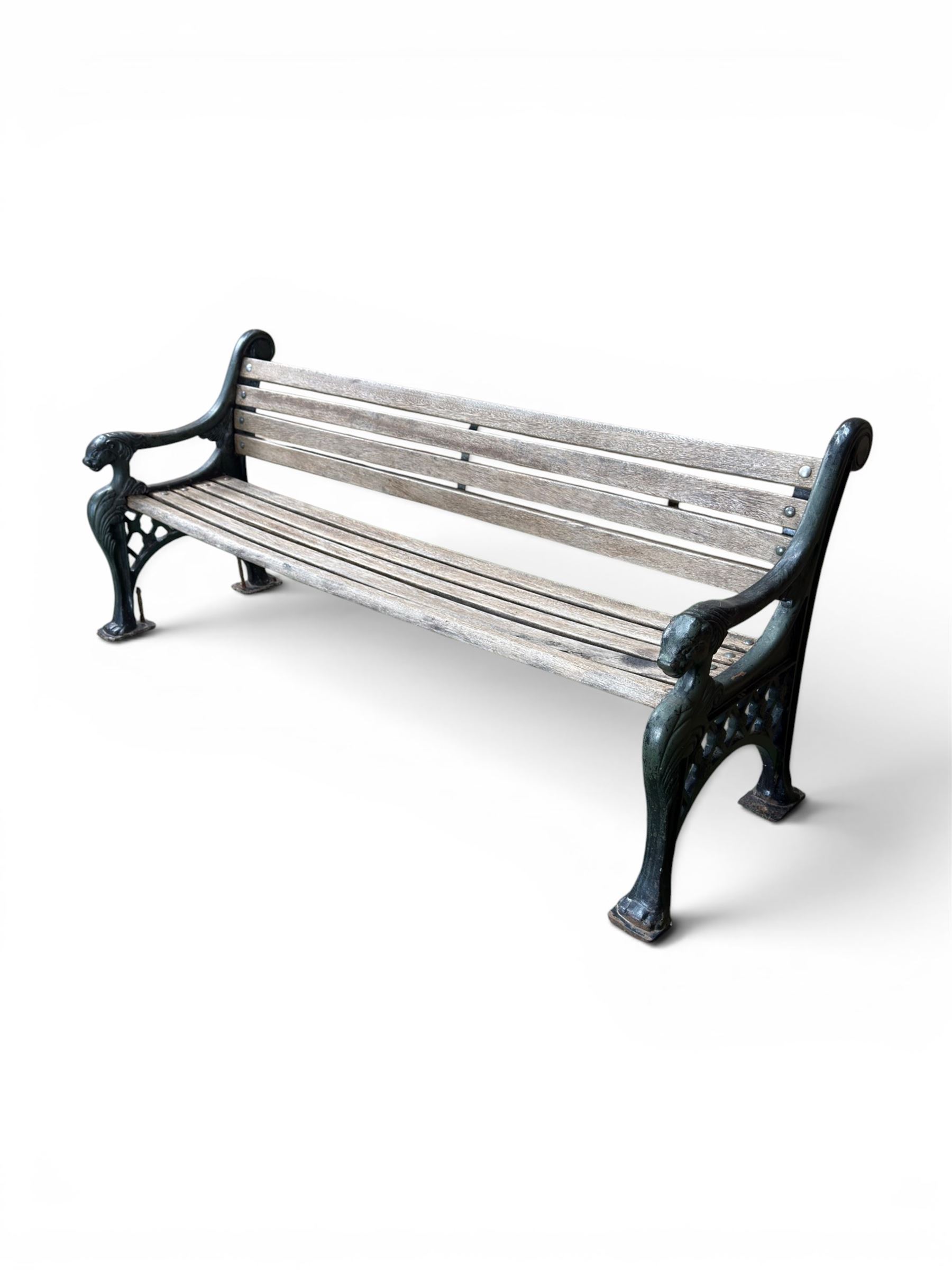 Neoclassical design cast iron and oak slatted garden bench, the twin end supports in the form of a Sphinx with acanthus carved knees and large paw feet, the pierced lattice bracket with Yorkshire rose motifs