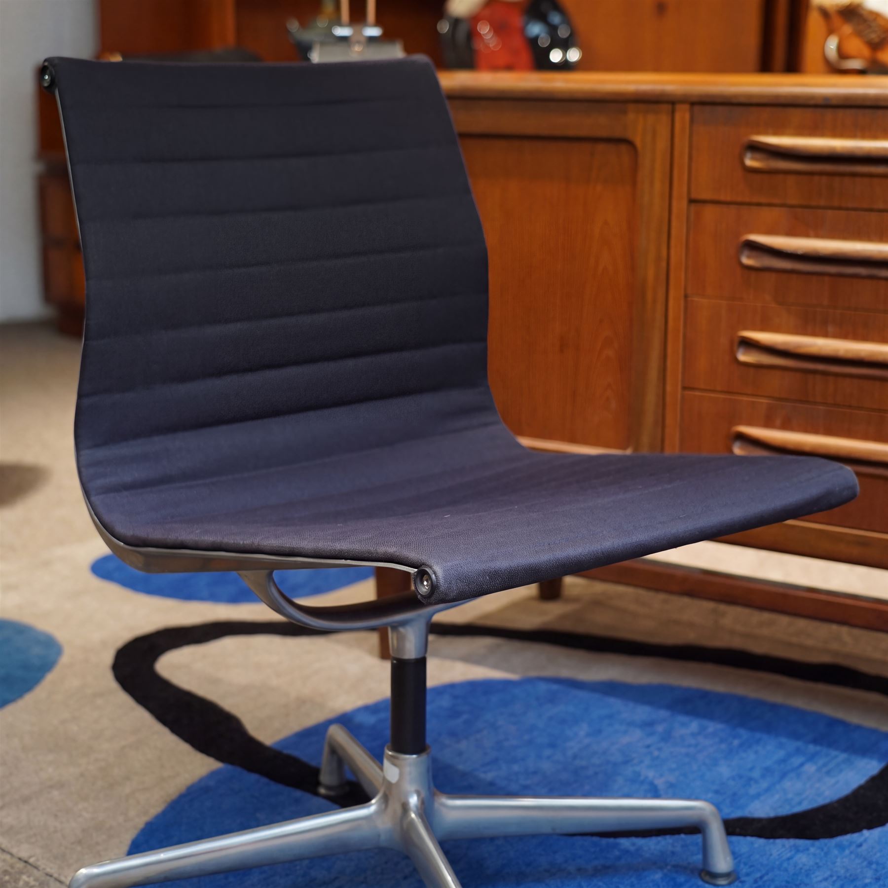 Charles and Ray Eames for Vitra - EA 105 chrome swivel chair upholstered in navy blue, raised on a four point chrome base