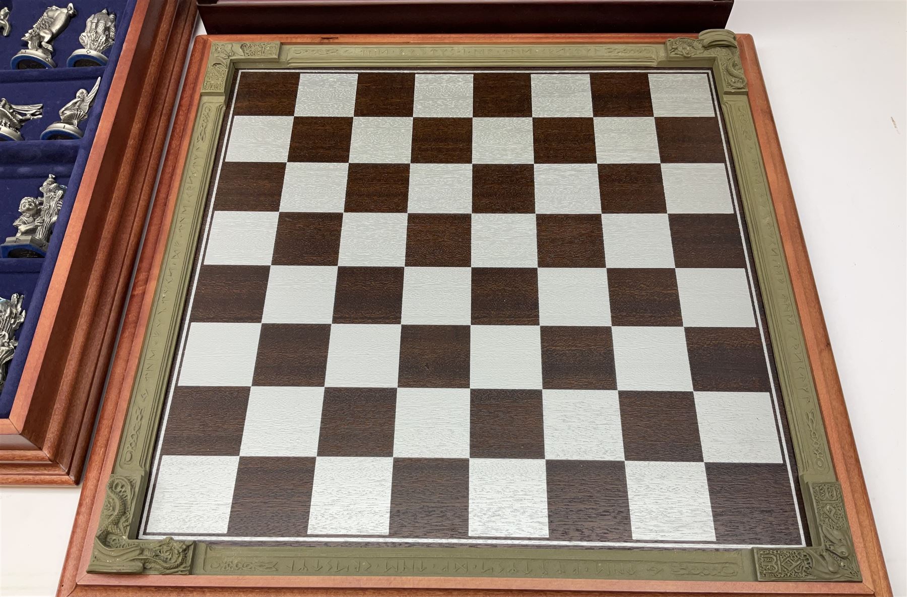 Danbury Mint 'The Fantasy of the Crystal' chess set consisting of mythical pewter chess pieces within a wooden case with chess board lid, together with 16 additional chess pieces in a wooden display case.