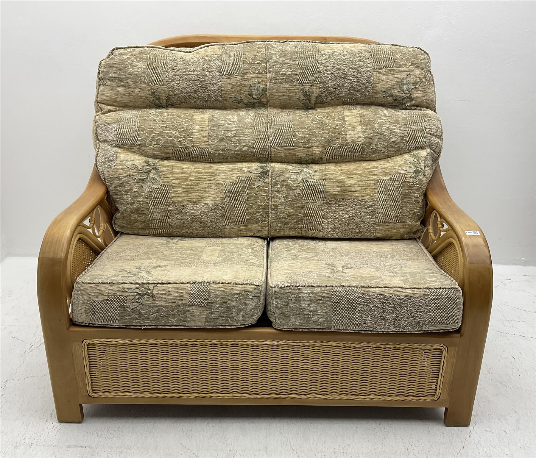 Light wood and cane two seat conservatory sofa, loose beige patterned cushions