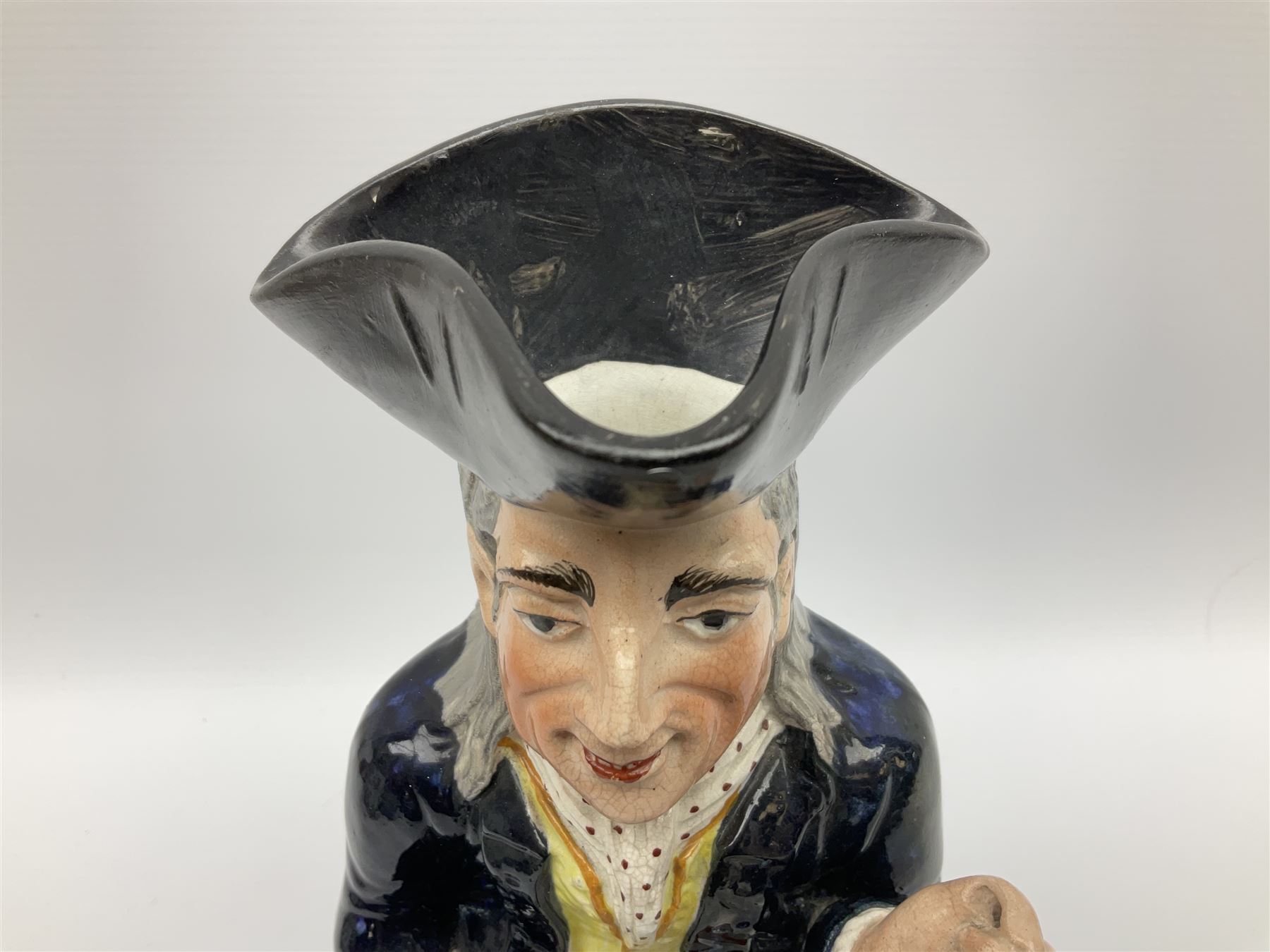 Early 20th century Staffordshire William Kent Squire toby jug, modelled seated upon a corner chair holding a jug of ale in his right hand, H28cm