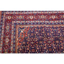 West Persian Mahal hand-knotted carpet, indigo field with central stylized angular medallion issuing an all-over Herati-inspired lattice of floral sprays, rosettes and geometric vinery in tone soft madder red, ivory and soft blue, principal border decorated with stylized palmettes, and angular vine motifs, flanked by multiple guard borders, with cotton fringe ends 