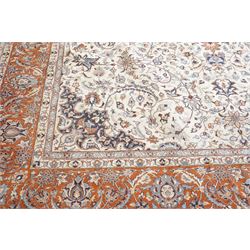 Persian ivory ground Kashan carpet, the busy field decorated with a central floral pole medallion with matching spandrels, the field profusely decorated with scrolling foliate motifs, the crimson guard stripe with repeating scrolling palmettes
