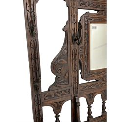 Victorian heavily carved oak hall-stand, moulded cornice with foliate carved decoration over bevelled mirror back, drop centre with hinged box seat flanked by stick or umbrella stands, scrolls and foliate carved decoration