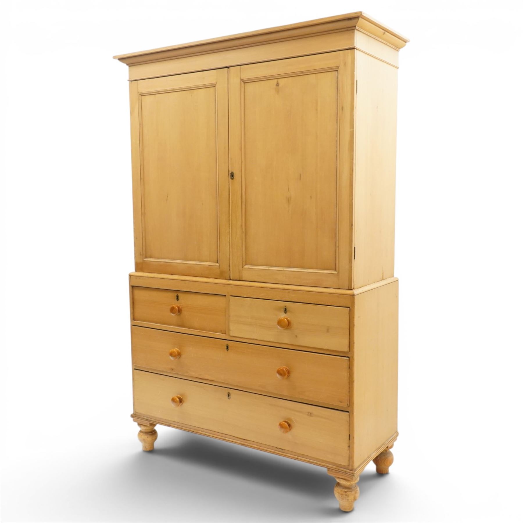 Victorian stripped pine housekeepers cupboard, projecting cornice over two panelled cupboard doors enclosing two shelves, the base fitted with two short over two long graduating drawers, lower moulded edge over turned feet