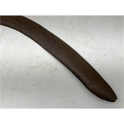 Australian aboriginal woomera spear thrower incised/carved with a wavy line and dots L69cm; and two boomerangs, one with carved geometric decoration (3)