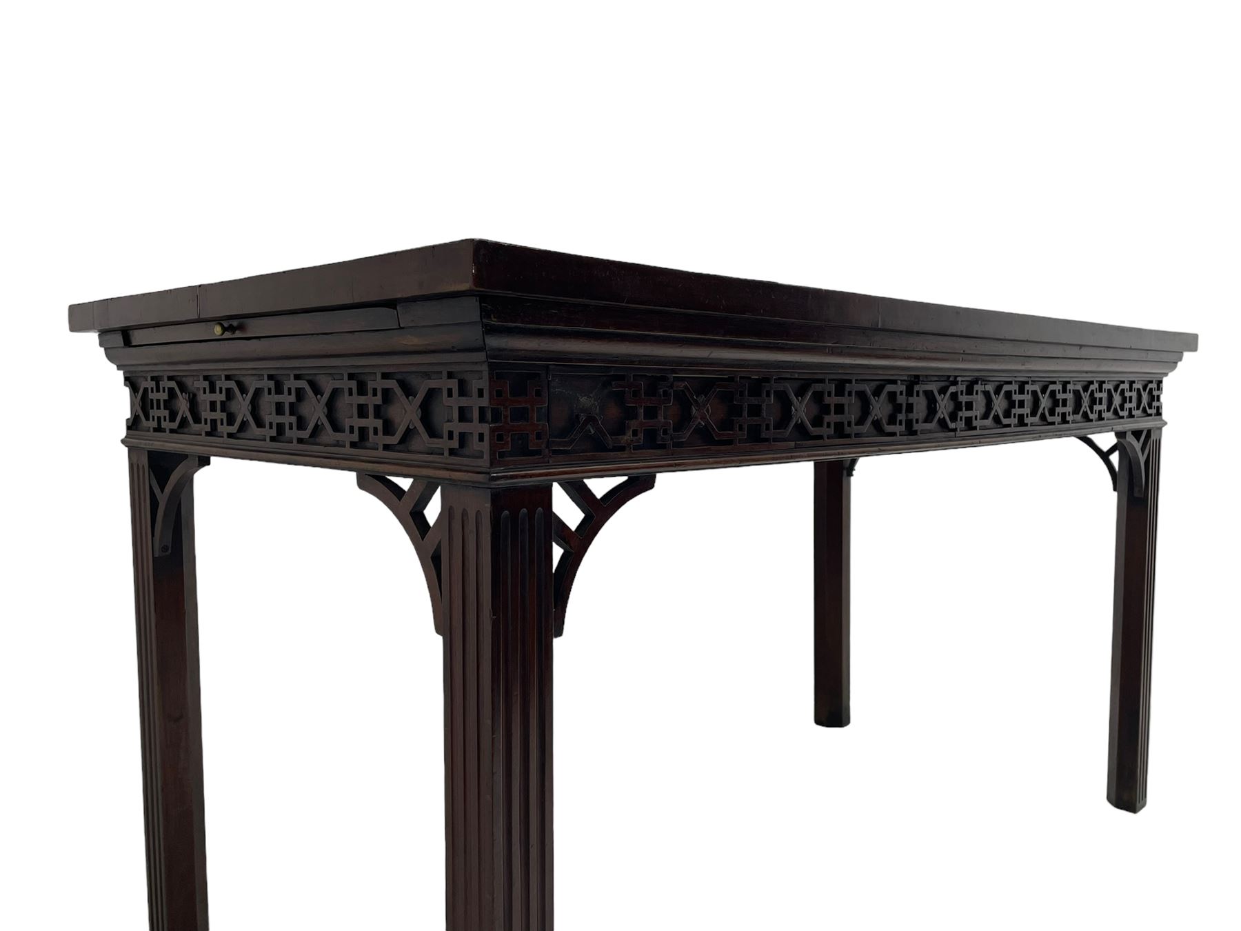 In the manner of Thomas Chippendale - early 19th century mahogany serving table, rectangular crossbanded top with boxwood stringing, the frieze with upper moulding over applied geometric fretwork, the left-hand side fitted with slide, on fluted square supports with inner chamfer 