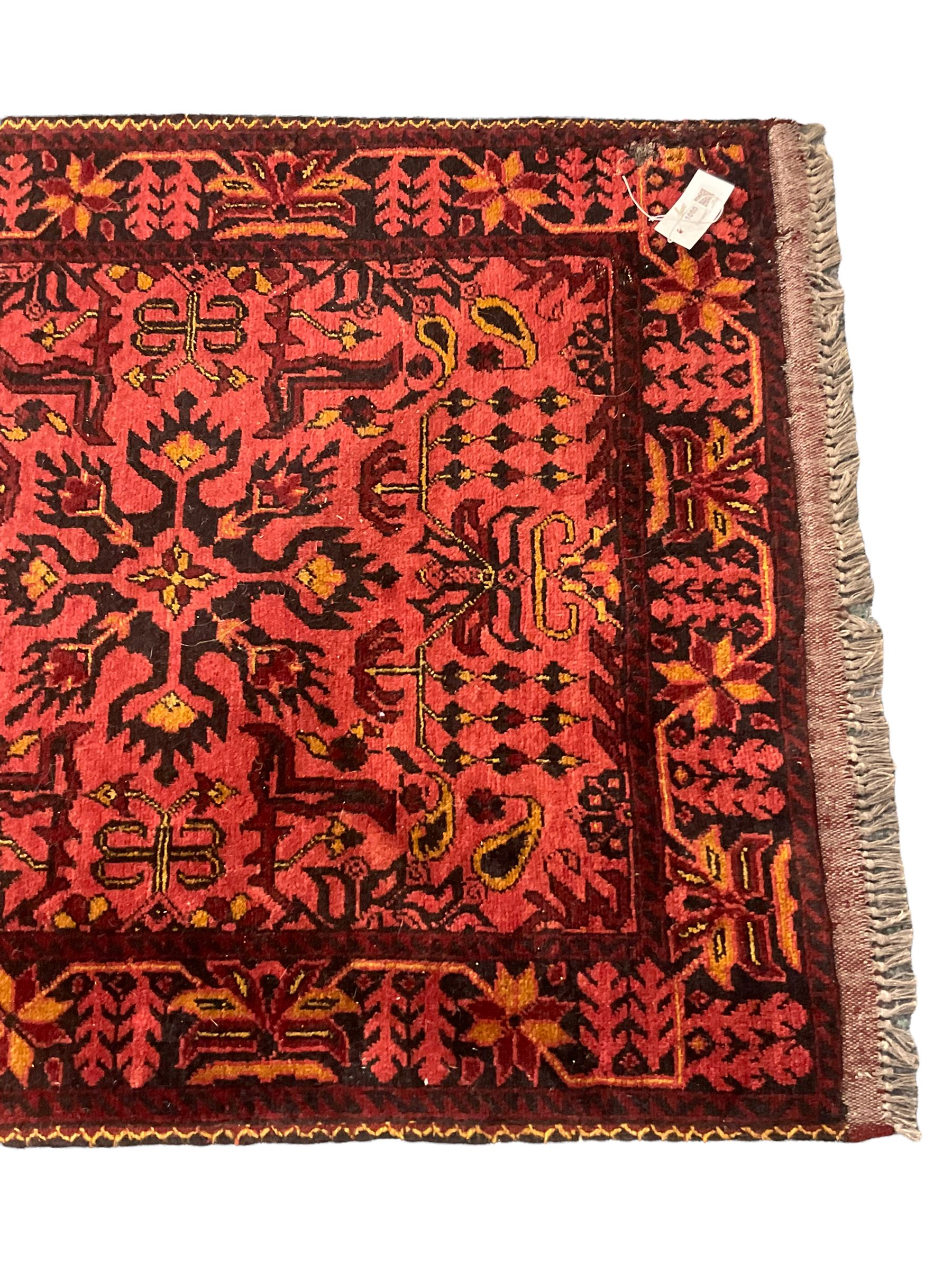 Persian red ground runner, decorated with four Herati motif medallions