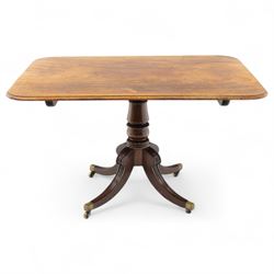 George IV mahogany breakfast table, rectangular tilt-top with reeded edge, rounded corners, supported on a turned column and raised on a quadripartite base with reeded down-swept legs terminating in brass cap castors