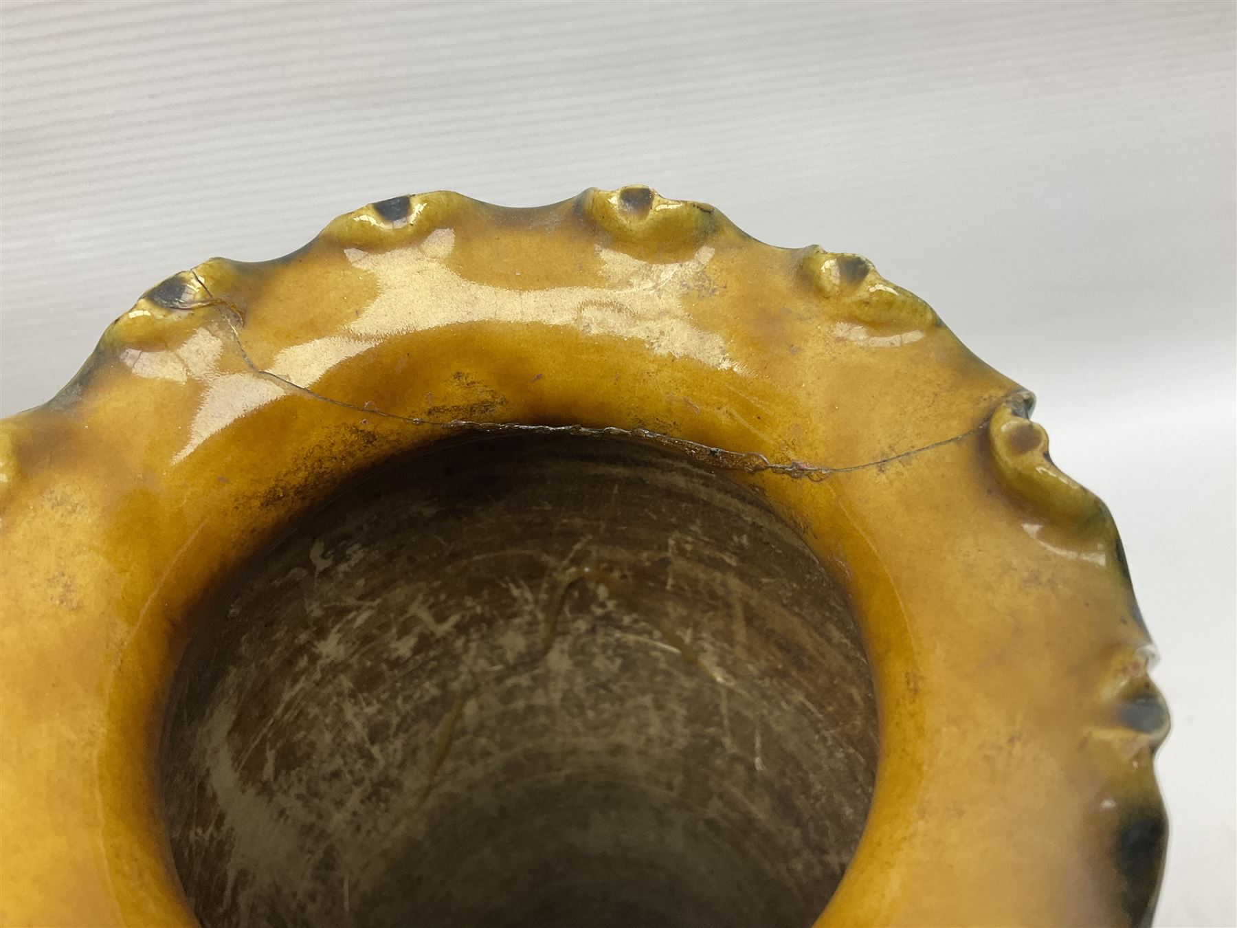 Early 20th century Royal Doulton stoneware vase, decorated with a stylized floral design below a wavy rim, monogrammed B.N, possibly for Bessie Newbery, H28cm, together with an early 20th century glazed jug, heavily carved throughout (2)