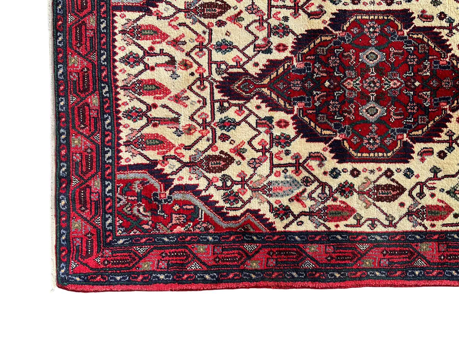 North West Persian Saveh crimson ground runner rug, the three lozenge pole medallions in an ivory field, surrounded by stylised plant motifs, the guarded border decorated with repeating geometric patterns