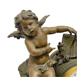 A French table clock c1900 on a white variegated rectangular marble base with four circular gilt feet, 8-day Parisian striking movement within a painted spelter drum case with putto, white enamel dial with floral garland decoration, Arabic numerals, minute track, gilt Louis XV hands and convex glazed bezel, movement striking the hours and half hours on a silvered bell. With Pendulum.  

